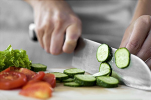 PACS-300x200-food1 A chef cutting vegetables on a cutting board