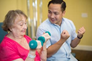 rehab therapist with a resident in the rehab gym at Poway Healthcare facility