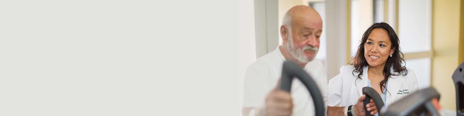 rehab therapist with a resident in the rehab gym at Poway Healthcare facility